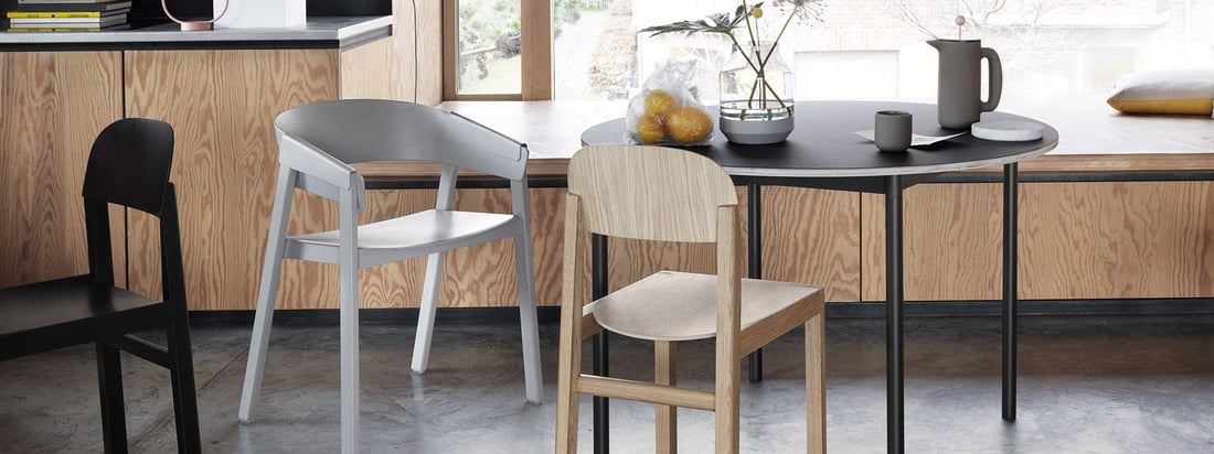 De Muuto Cover stoel van hout met een zwarte tafel en grijze stoel passend bij de Japandi trend.