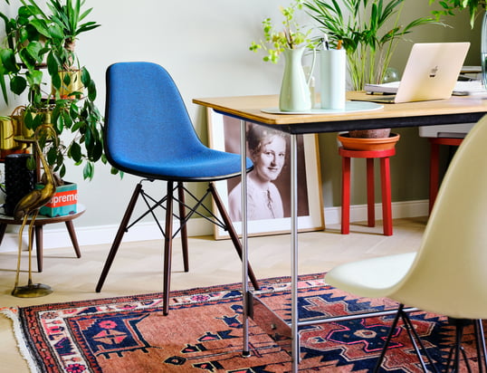 De Eames Plastic Side Chair DSW van Vitra in de ambiance-optiek: De filigraan stoel wordt door het felle blauw een absolute blikvanger in de woonkamer.