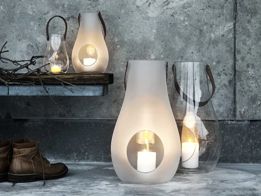 Een schoolvoorbeeld van stijlvolle en mooie cadeaus voor vrouwen: de Design with Light lantaarn van Holmegaard gemaakt van transparant of mat wit glas en een leren handvat.