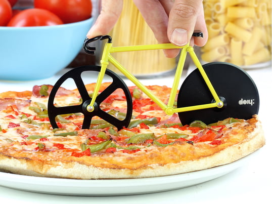 De snijder is een kleine fiets, die over de pizza heen wordt gestuurd en met zijn twee messen in stukken wordt gesneden.