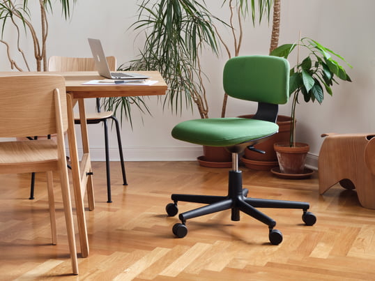 De bureaustoel Rookie van Vitra in de ambiance-optiek: de groene bureaustoel kan in hoogte worden versteld en past zich zo optimaal aan elke tafelhoogte aan.