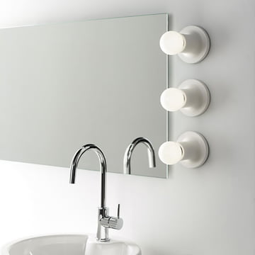 Punt wand- en plafondlamp van Carpyen in wit naast de spiegel