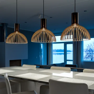 De Victo Small 4251 hanglamp van Secto boven een lange, witte eettafel.