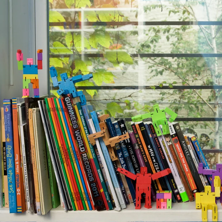 De Cubebot van Areaware als decoratie op boeken