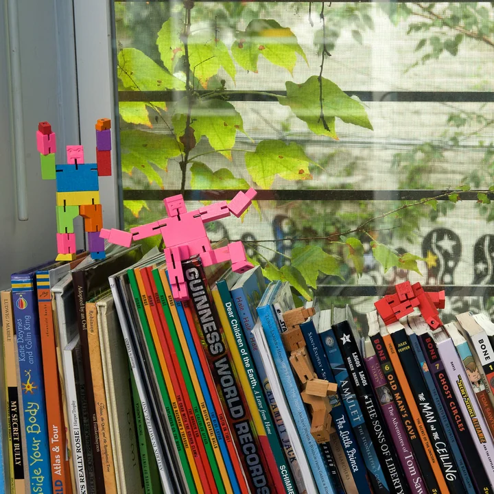 De Cubebot van Areaware klimt op stapels boeken