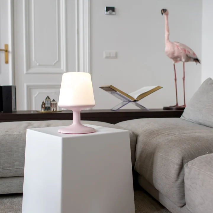 Lichte batterij gevoede tafellamp in organisch roze van Koziol op de koffietafel