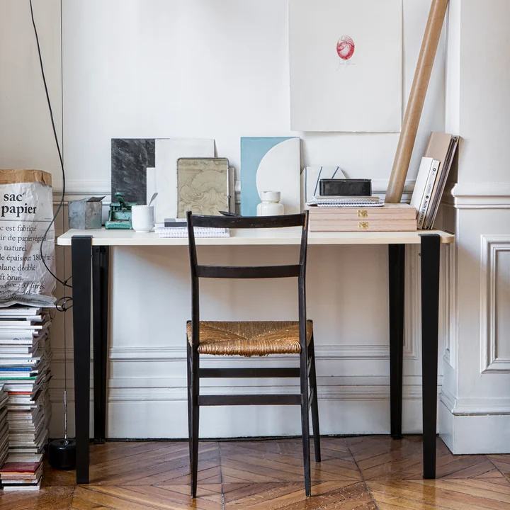 De tafel en bureaupoot H 75 cm, grafiet zwart van TipToe aan een werktafel in het atelier.