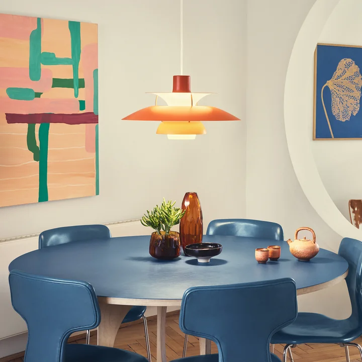 De PH 5 hanglamp, oranje tinten van Louis Poulsen boven een eetkamertafel