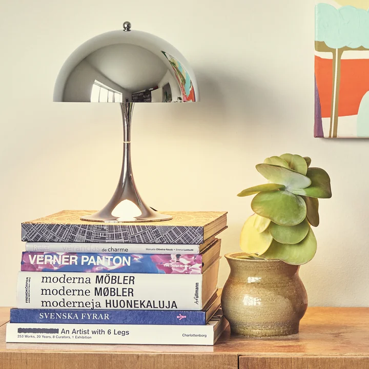 Louis Poulsen De Panthella hoogglans verchroomd uit als decoratief object op salontafel boeken