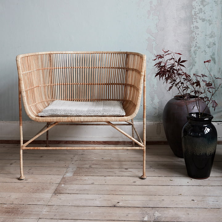 De Cuun Rattan Lounge Chair, naturel van House Doctor in de woonkamer naast kamerplanten