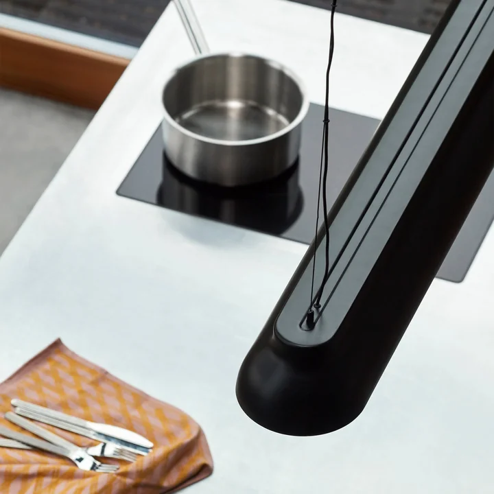 De PC Lineaire staaf hanglamp, zacht zwart van HAY boven het kookeiland