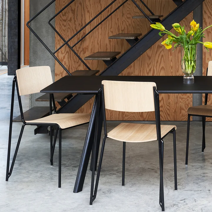 De Petit Standard stoel, zwart / eiken mat gelakt door HAY op een zwarte tafel naast de trap