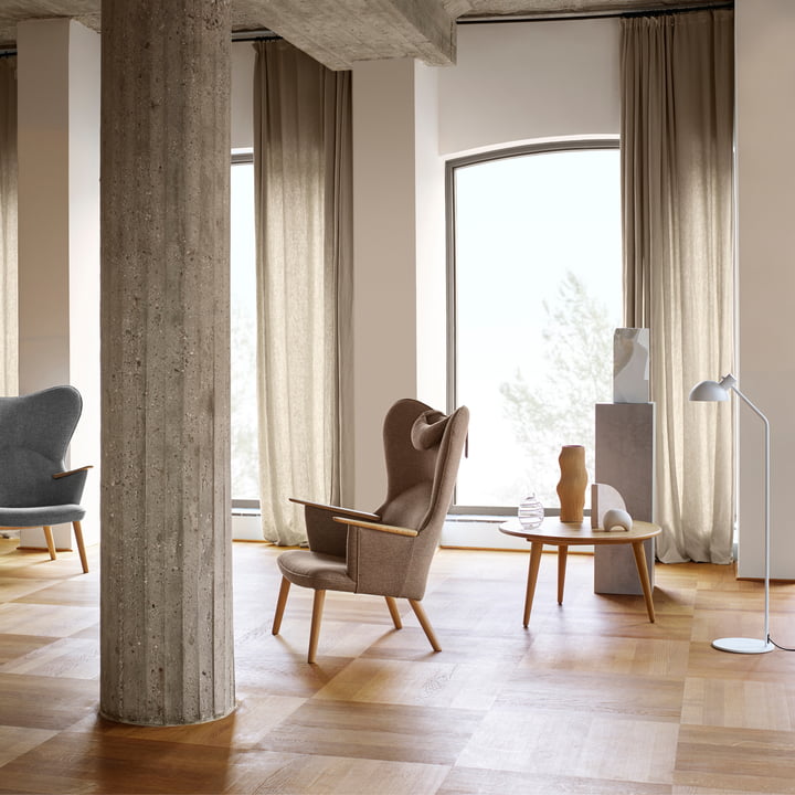 De CH78 Mama Bear Lounge Chair van Carl Hansen in een lichte kamer met stenen zuilen en houten vloer