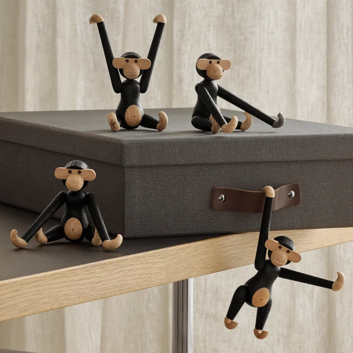 De houten aap mini, zwart gebeitst eiken van Kay Bojesen op en op een opbergdoos
