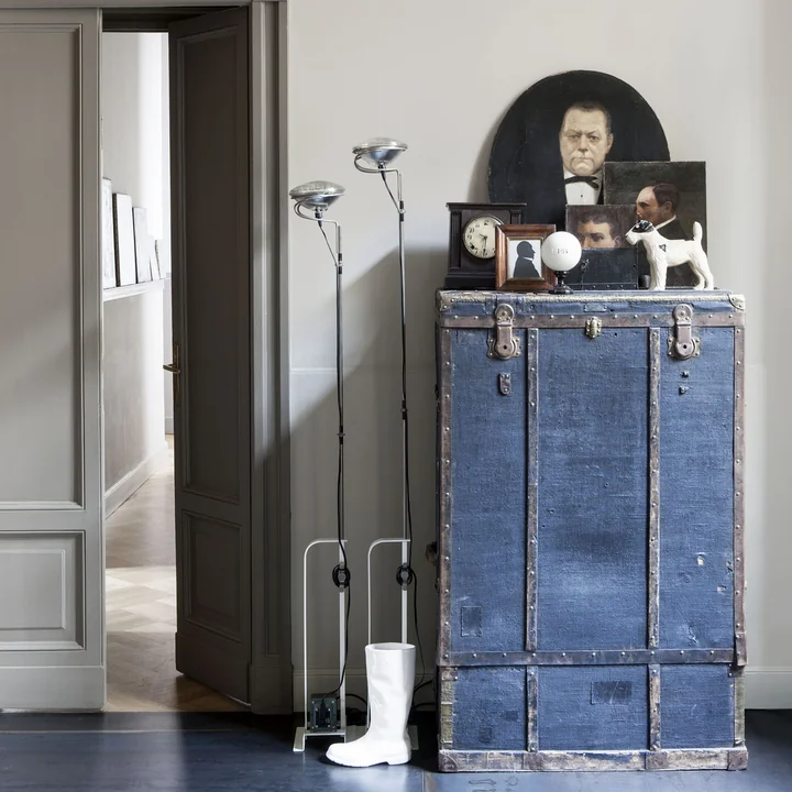 De Toio plafondlamp van Flos naast een ladekast in de hal