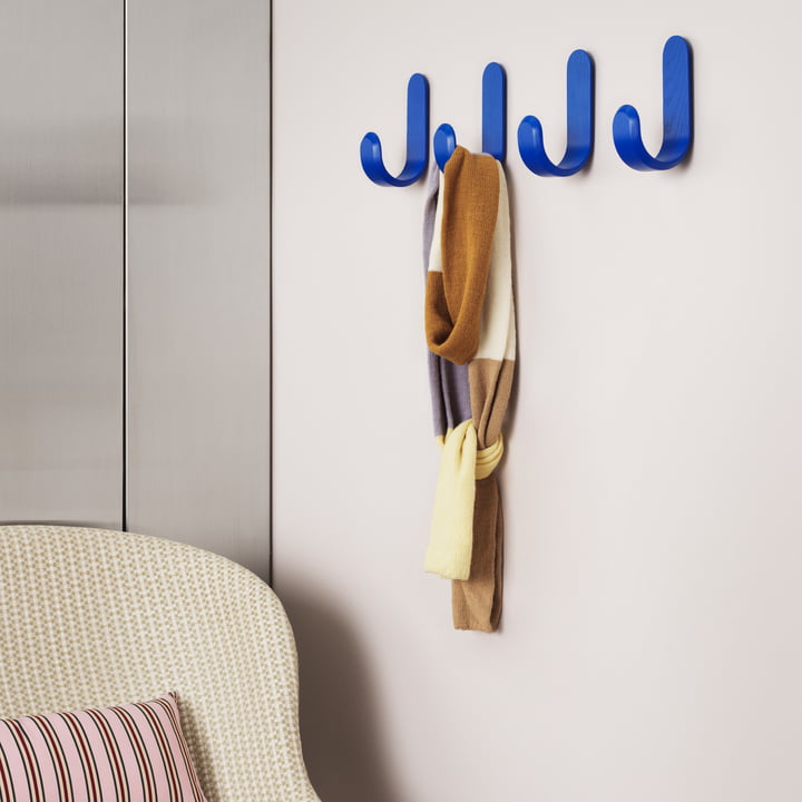 De blauwe Curve Muurhaak van Normann Copenhagen kan gebruikt worden om sjaals op te hangen