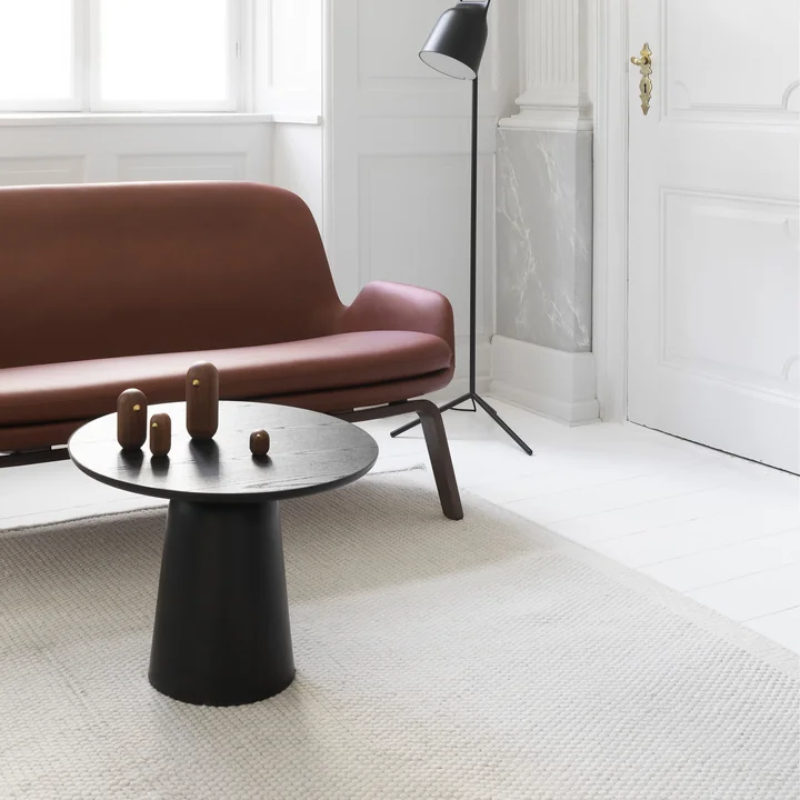 De Turn salontafel van Normann Copenhagen voor een leren bank in een lichte woonkamer