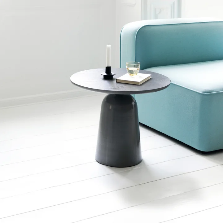 De Turn salontafel van Normann Copenhagen naast een turquoise bank