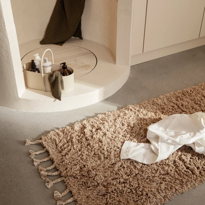 De Amass hoogpolige loper van Ferm Living naast de stenen douche in de badkamer