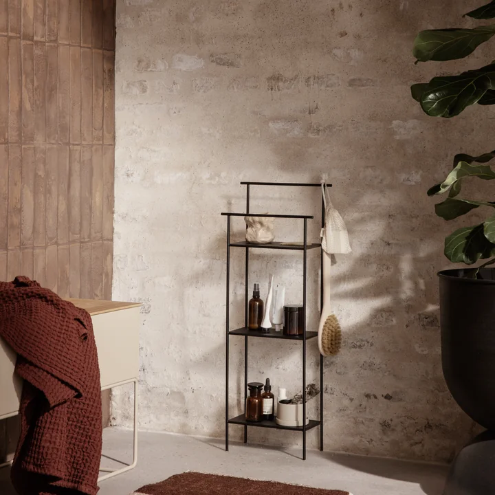 De Dora badkamerplank van Ferm Living met badkameraccessoires naast een grote kamerplant