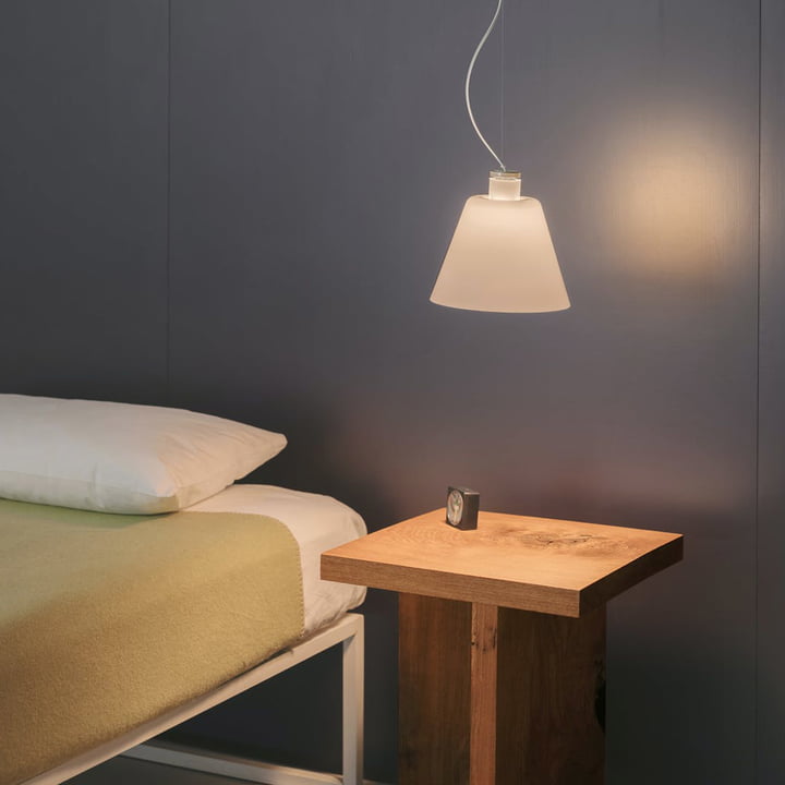 De w202 Halo LED hanglamp S2 van Wästberg boven het houten nachtkastje naast het bed.