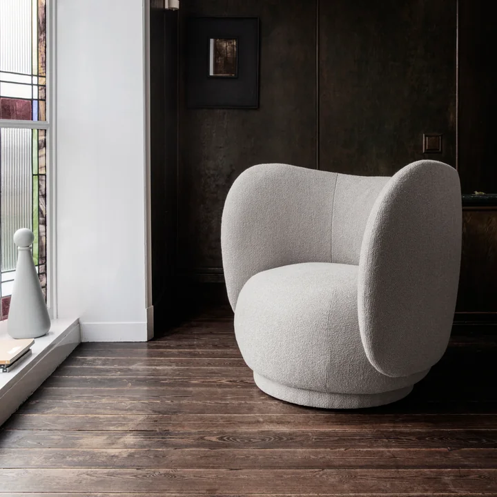 Rico Lounge Chair De van Ferm Living op een donkere parketvloer voor een voorraam