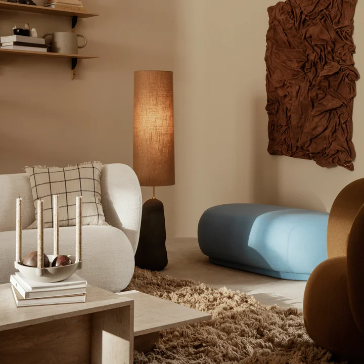 De Rico Sofa van Ferm Living op een bruin tapijt achter een travertijnen salontafel