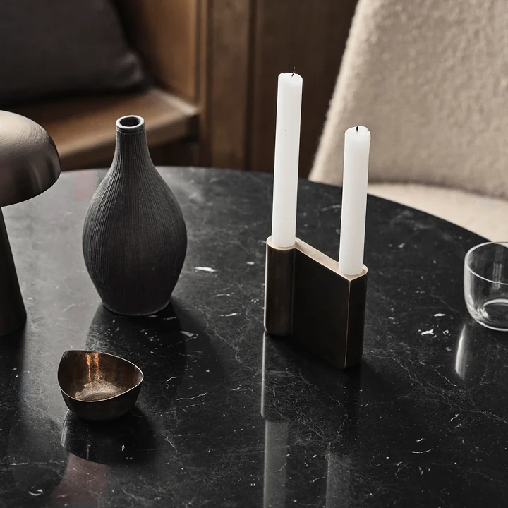 De Collect kandelaar van & Traditie met witte kaarsen op een zwarte marmeren tafel.