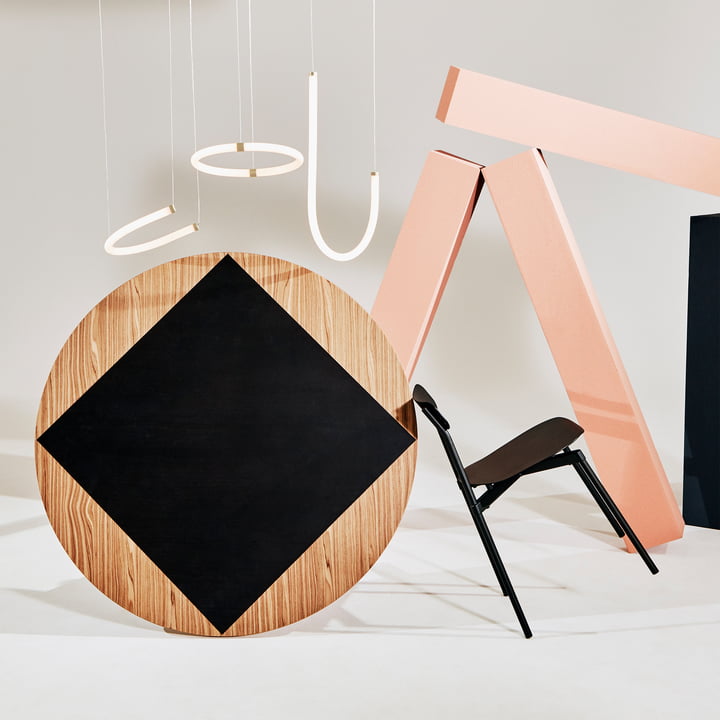 De Unseen hanglamp van Petite Friture in messing met geometrische kunstobjecten in roze en zwart.