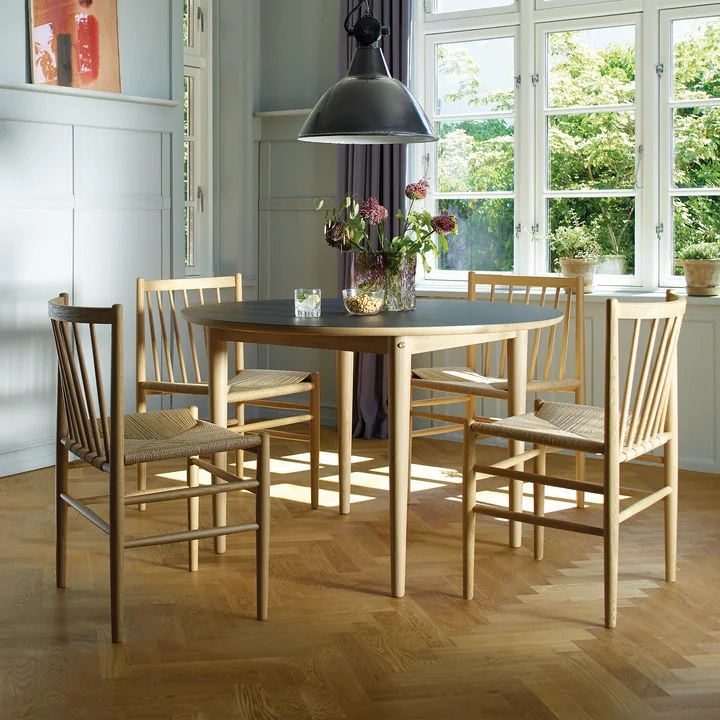 J80 FDB Møbler De stoel van eikenhout aan een lichtgekleurde eettafel in een kamer in landelijke stijl