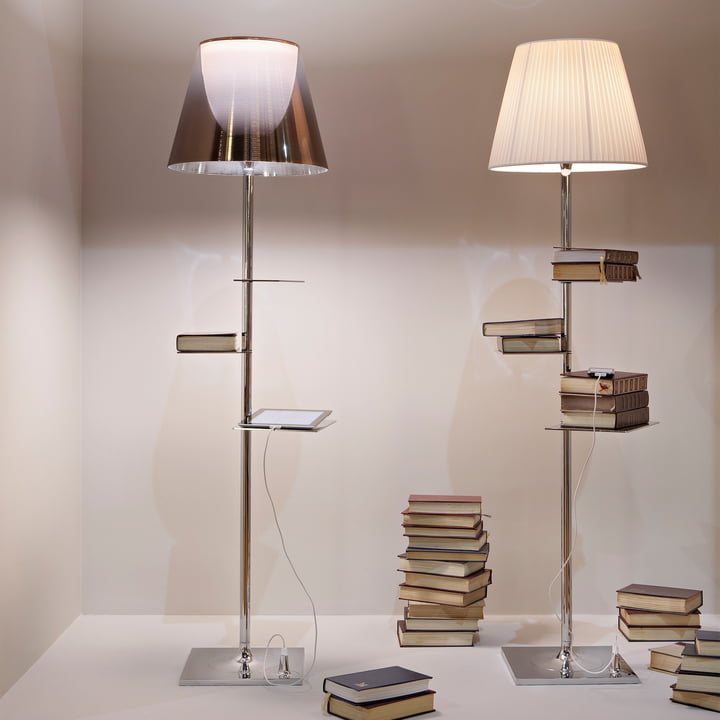 De glimmende Bibliotheque Nationale vloerlamp van Flos wordt omringd door boeken.