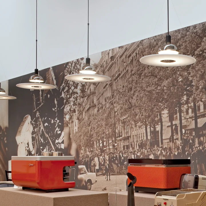 De Frisbi hanglampen van Flos in een restaurant voor een grote foto.