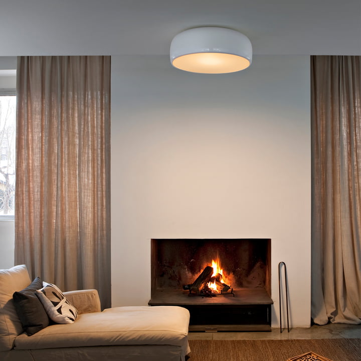 De Smithfield Pro plafondlamp van Flos in de woonkamer boven een beige bank met open haard