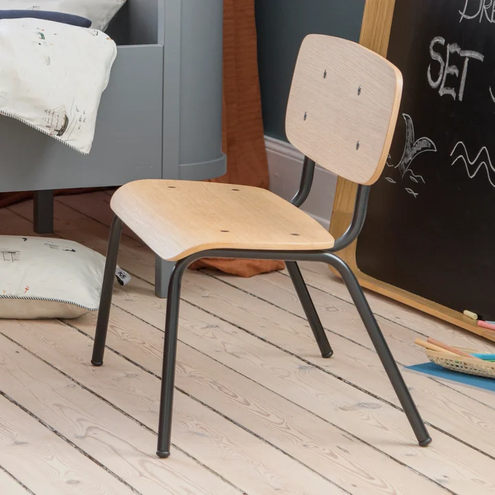 De Oakee kinderbank van Sebra naast het bed in de kinderkamer.