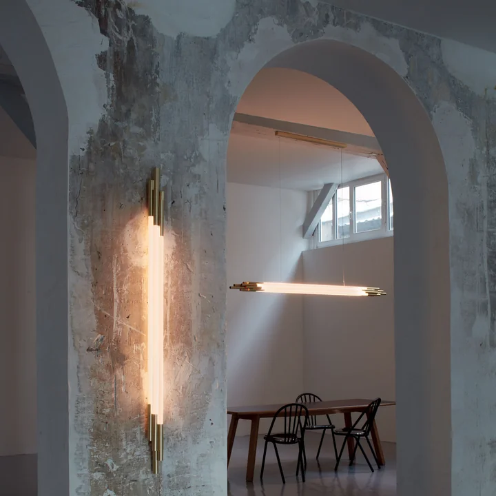 De Org LED wandlamp en hanglamp van DCW in een ruwe ruimte met hoge plafonds.
