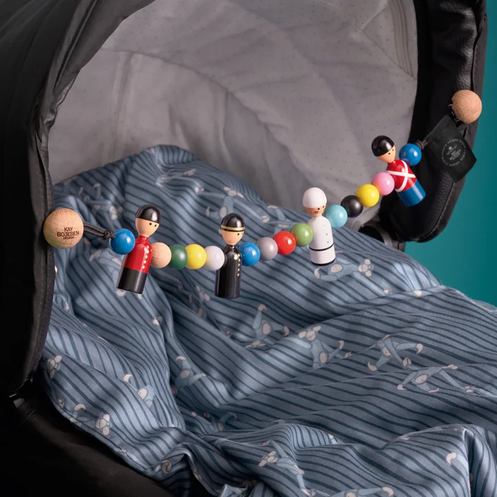 De liefdevolle houten ketting op de kinderwagen