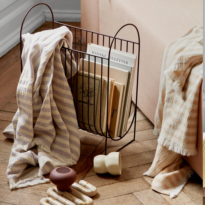 De Maggie tijdschriftenhouder van Broste Copenhagen met boeken en een overgooier