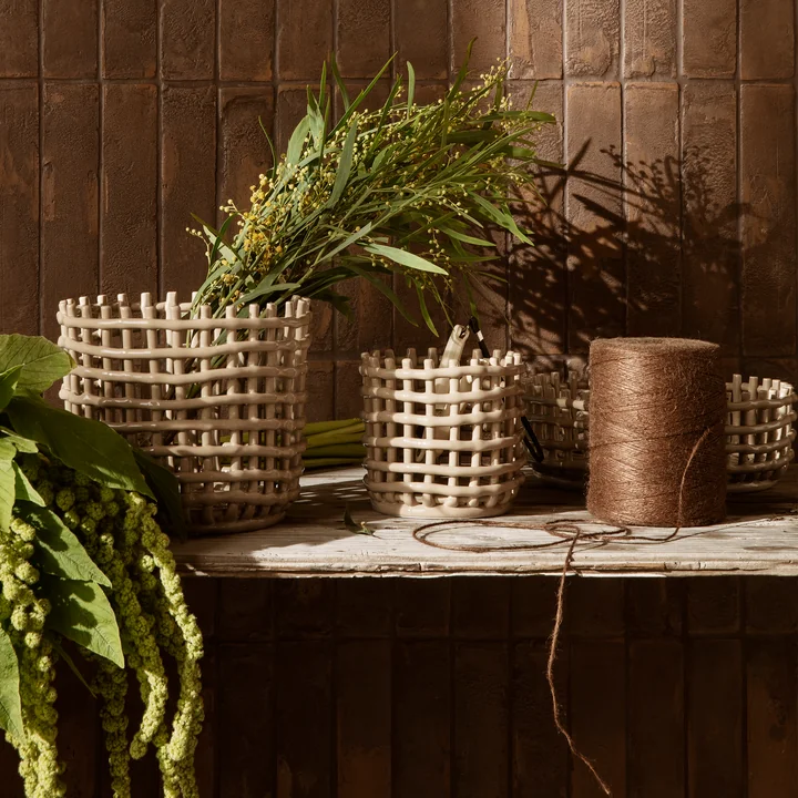 De keramische manden van Ferm Living met planten op een houten bankje