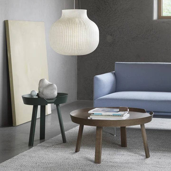 De Around tafels van Muuto naast een lichtblauwe bank in de woonkamer