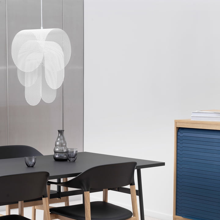 De Superpose hanglamp van Normann Copenhagen boven een zwarte tafel