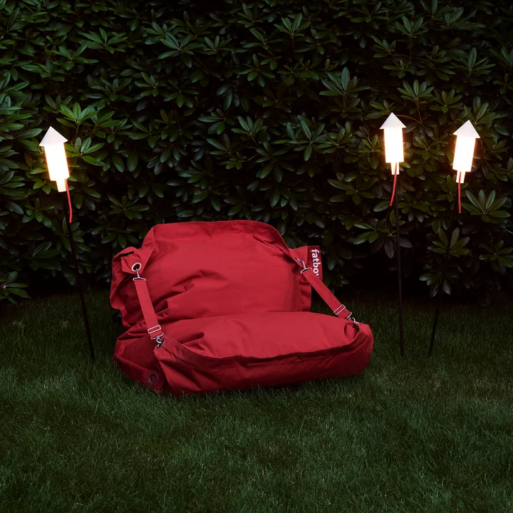 De Prêt a Racket solarlamp in de tuin naast een bank van Fatboy