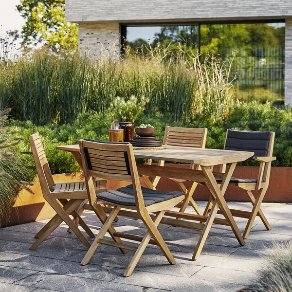 De Flip klapstoel Outdoor van Cane-line op het groen beplante terras